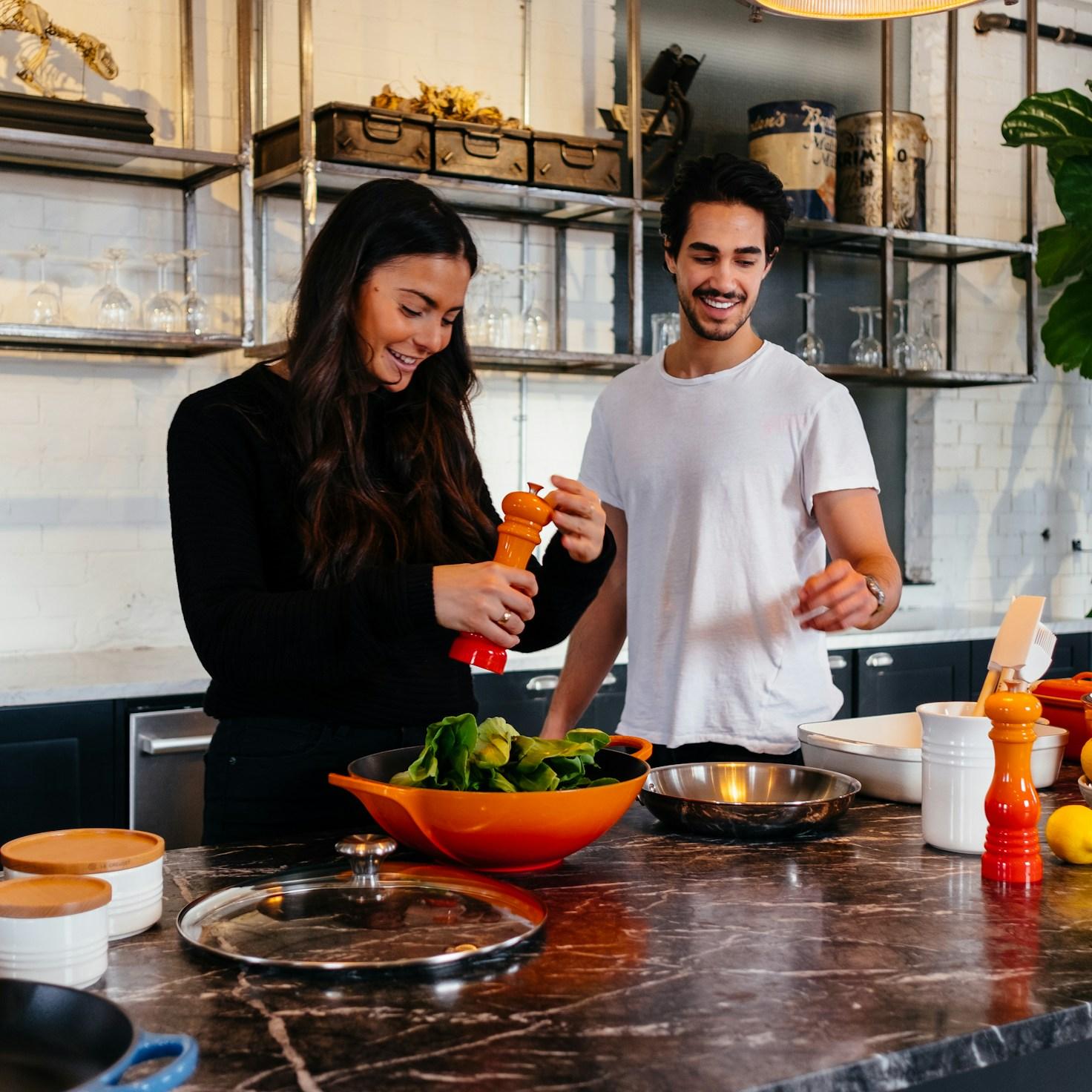 Community members working together in a contemporary kitchen, exchanging recipes and techniques